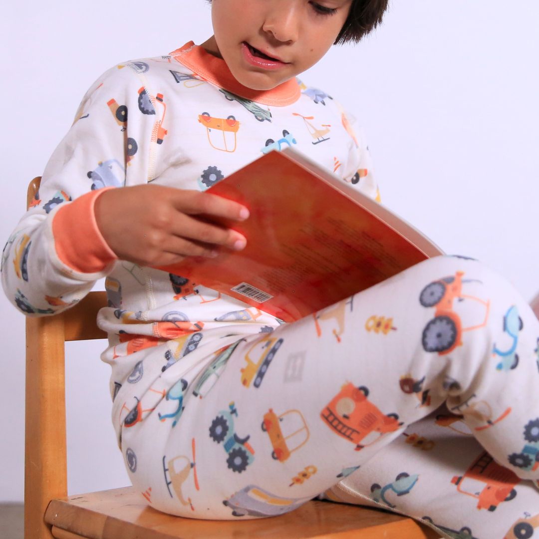 Child wearing Organic pajamas made in San Francisco with vintage cars and trucks prints. Detail of flatlog seam for sensitive skin. 100% cotton threads to avoid irritation.