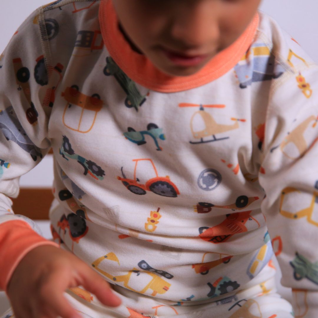 Child wearing Organic pajamas made in San Francisco with vintage cars and trucks prints. Detail of flatlog seam for sensitive skin. 100% cotton threads to avoid irritation. 