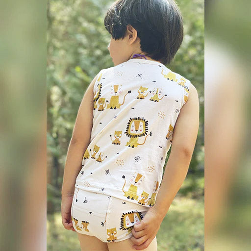 A child wearing Mukupati's potty training with a matching top of Lion's print over a cream background