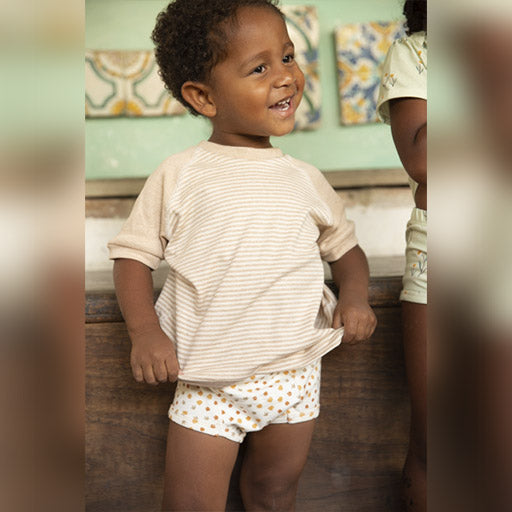 Boy smiling wearing organic pima cotton t-shirt and mukupat's organic potty training pants