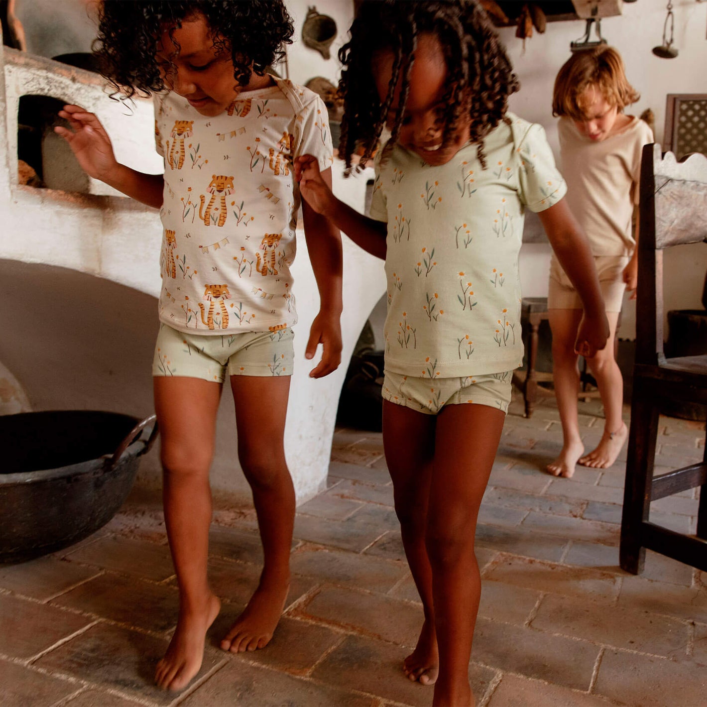 Two girls walking waaring Mukupati's happy tops and potty training underwear with daisies and tiger prints.